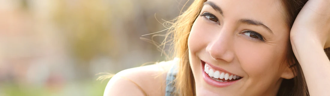 Dentist Canoga Park CA 3D Printing A smiling woman who's expression is engaging with light brown hair and eyes shows her bright, white teeth in a close-up.